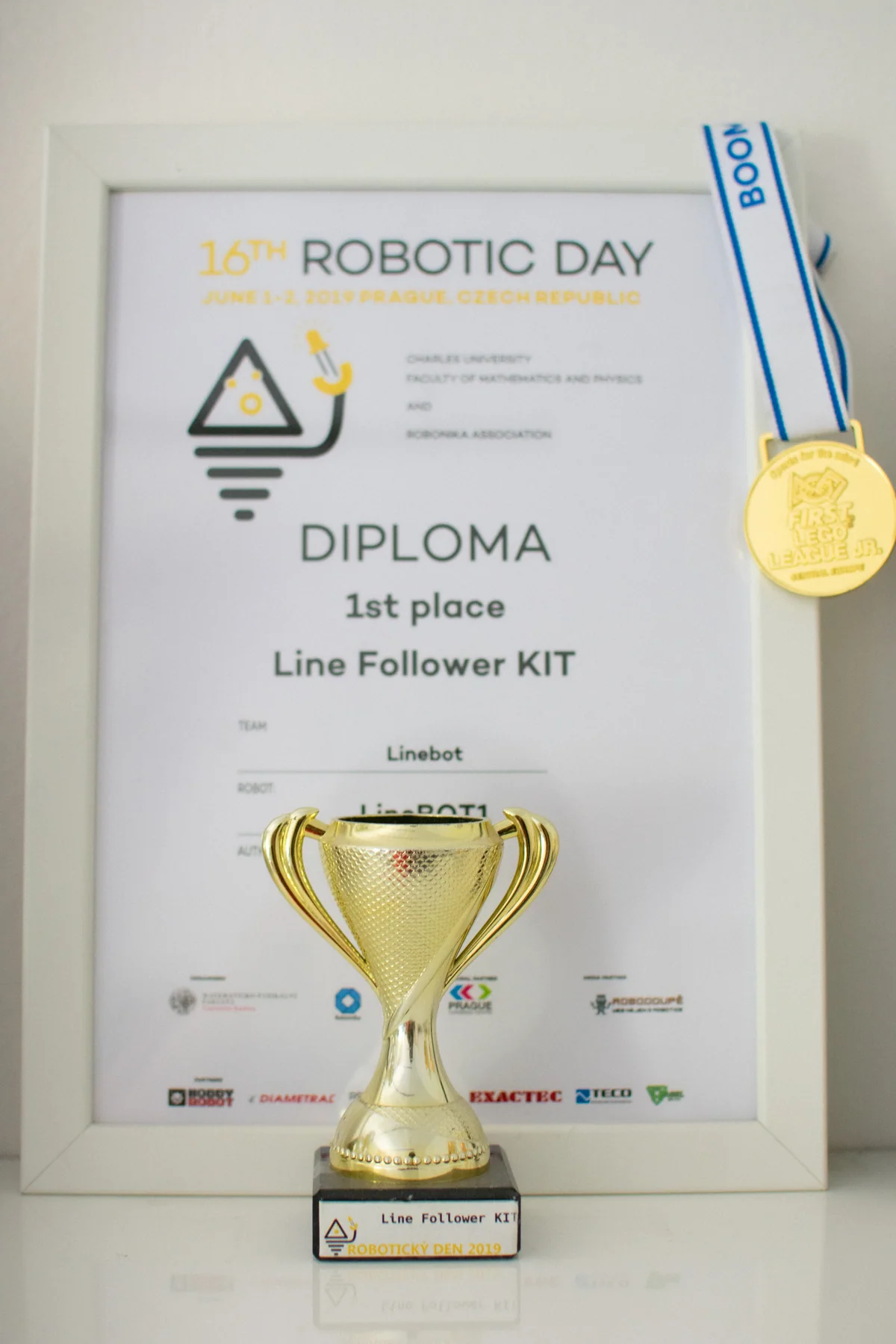 Pohár, diplom a medaile za první místo v Line Follower KIT na Robotickém dni 2019