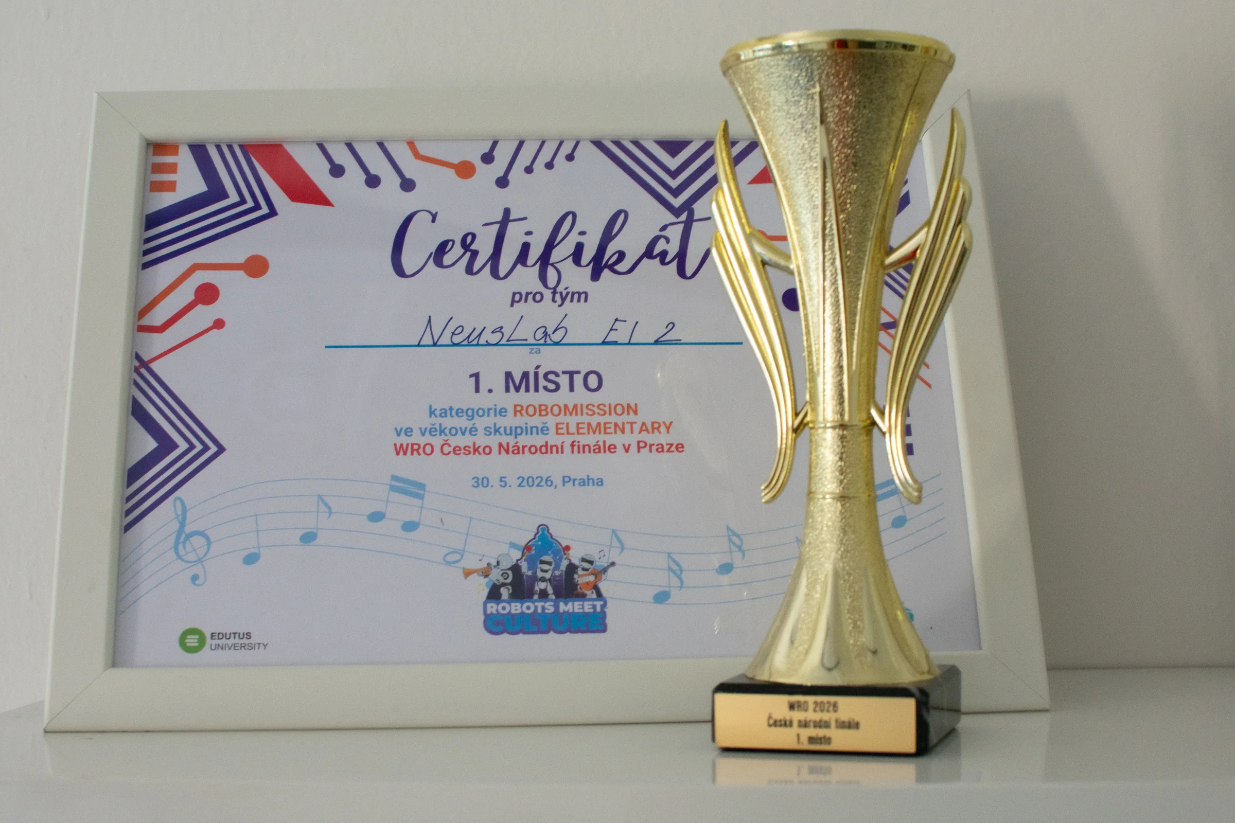 Pohár za první místo na WRO 2026 před certifikátem týmu
