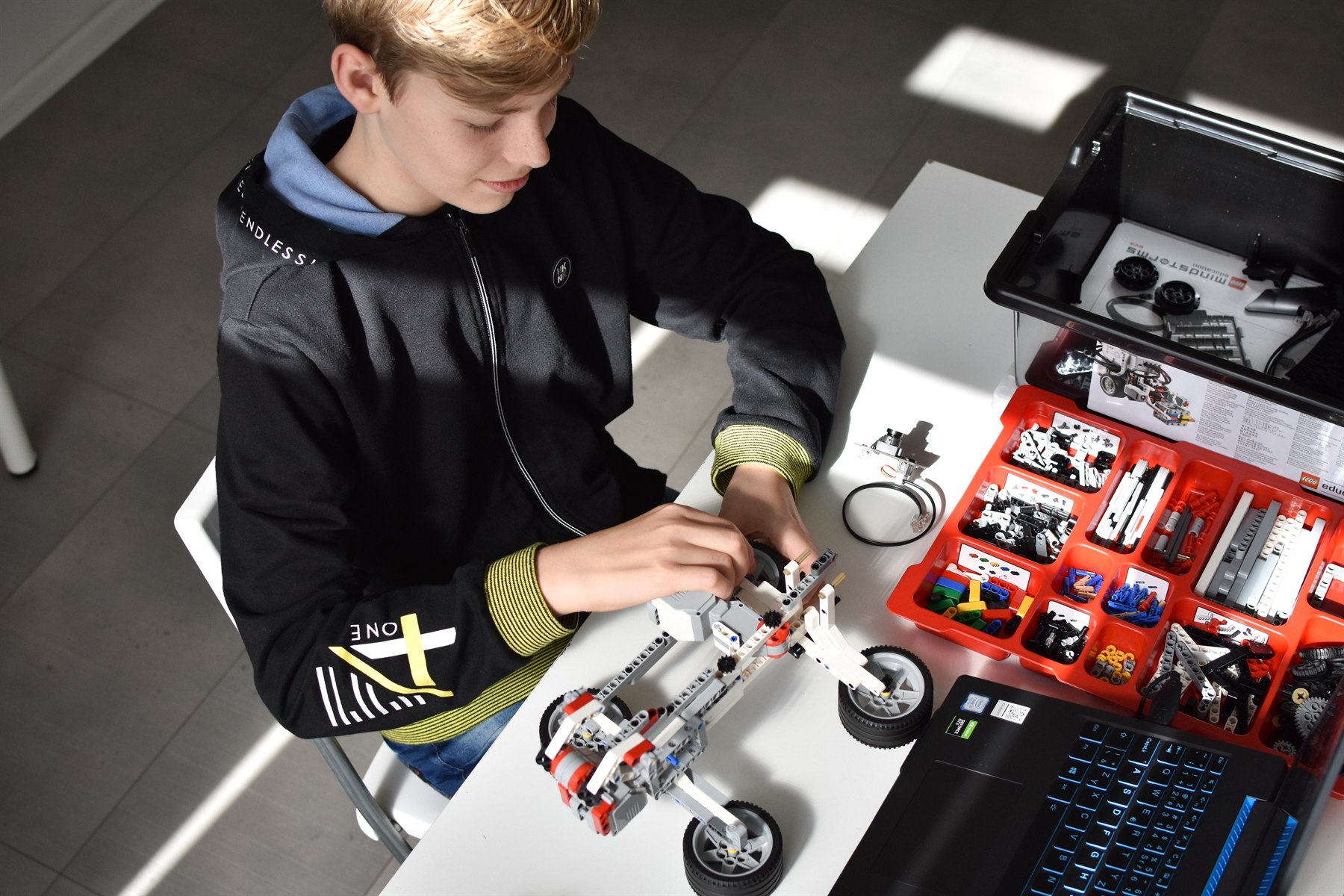 A student building and testing an advanced LEGO robot
