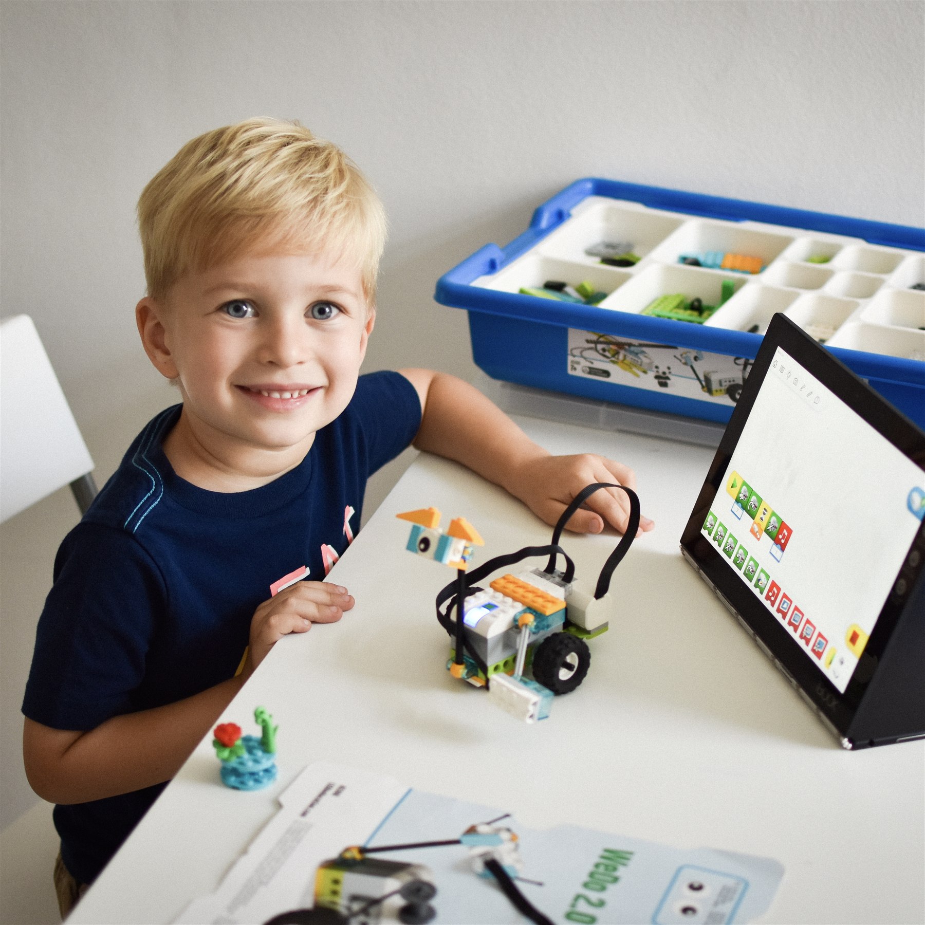 A young child programming and testing a LEGO robot